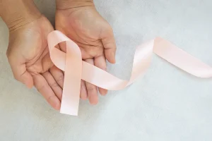 Imaginea surprinde o mână care ține o fundă portocalie, simbol al speranței și susținerii pentru pacienții cu cancer endometrial. Aflați mai multe despre opțiunile de tratament și sprijinul disponibil în articolul nostru specializat.